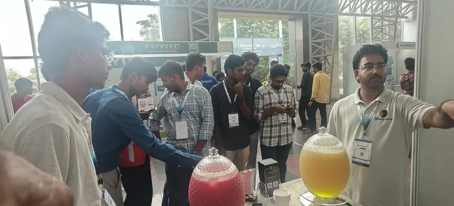 Visitors gathered at the Dharanova booth in the late morning, cups in hand, the two juice jars on the table.