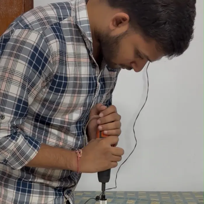 Harsha Vardhan Patri drilling into a round wooden base.