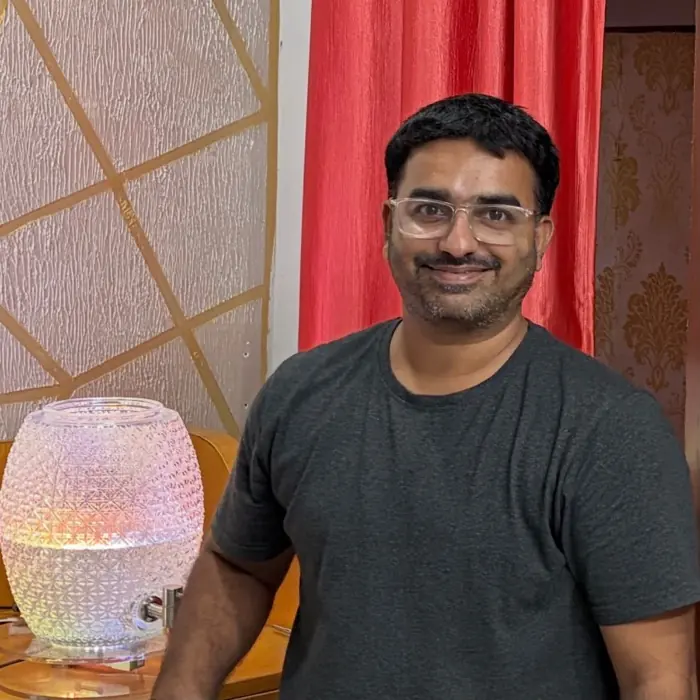 Nanupatruni Mahesh Kumar standing beside one of the lit jars.
